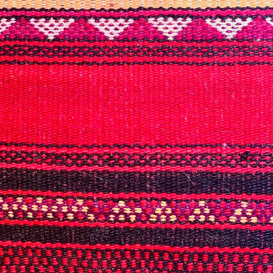 Detail tkaného kelimu v růžové a červené